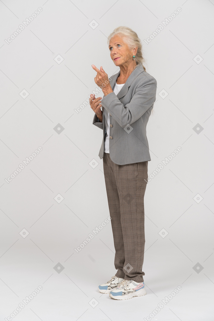 Side view of an old lady in suit pointing with finger