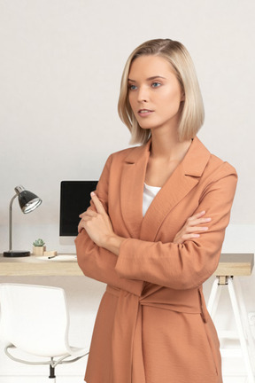 A woman standing in front of a desk with a computer