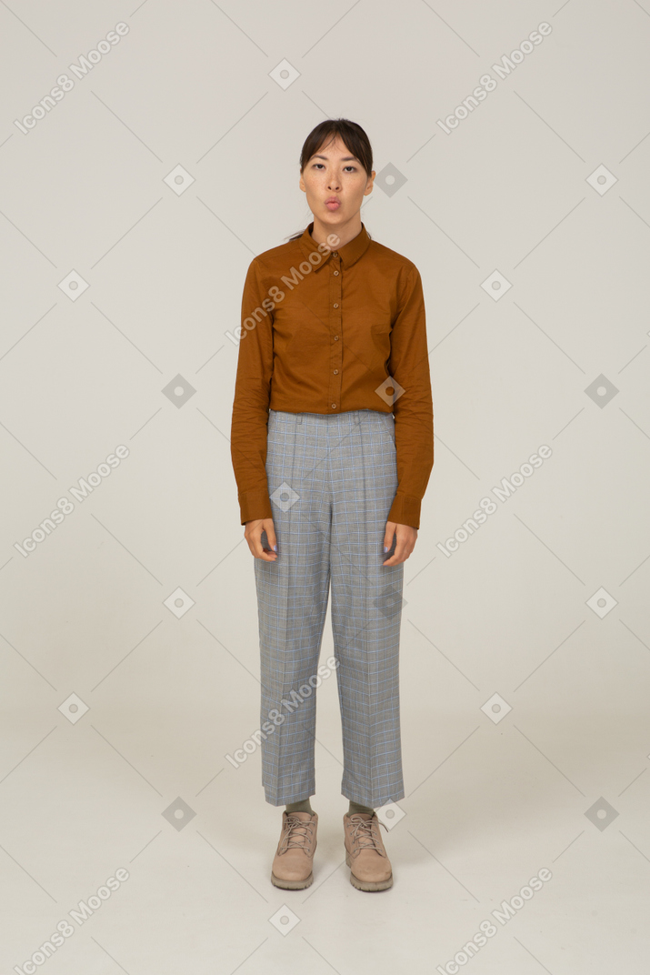 一个穿着马裤和衬衫的顽皮的年轻亚洲女性的前视图