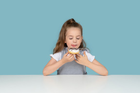 Niña linda mirando un donut