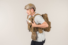 Male hot zone journalist in bulletproof vest standing half sideways
