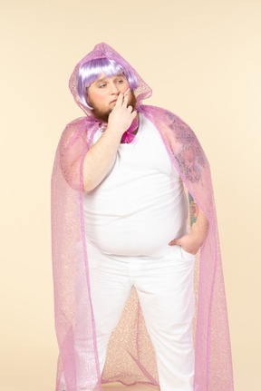 Young plump man in fairy cape smoking a cigarette with eyes closed