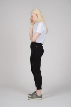 Profile view of a young woman touching her head