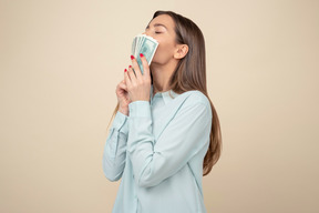 Attractive young woman kissing dollar bills