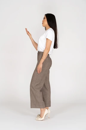 Vista lateral, de, un, señorita, en, calzones, y, camiseta, levantar la mano