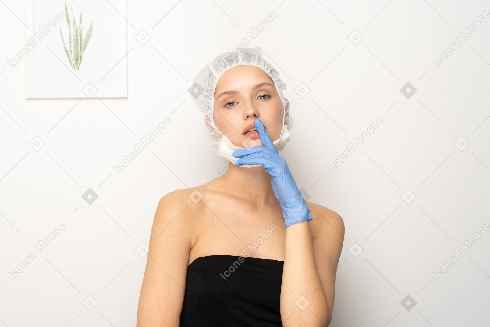 Young woman in scrub cap holding finger to lips