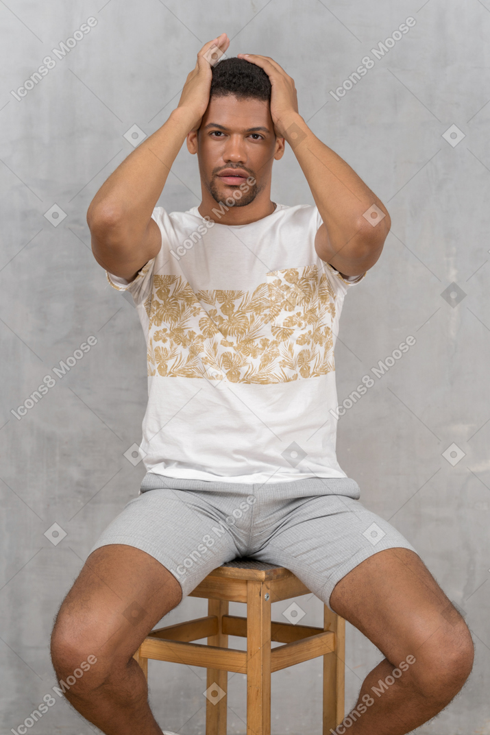 Young man sitting and fixing hair