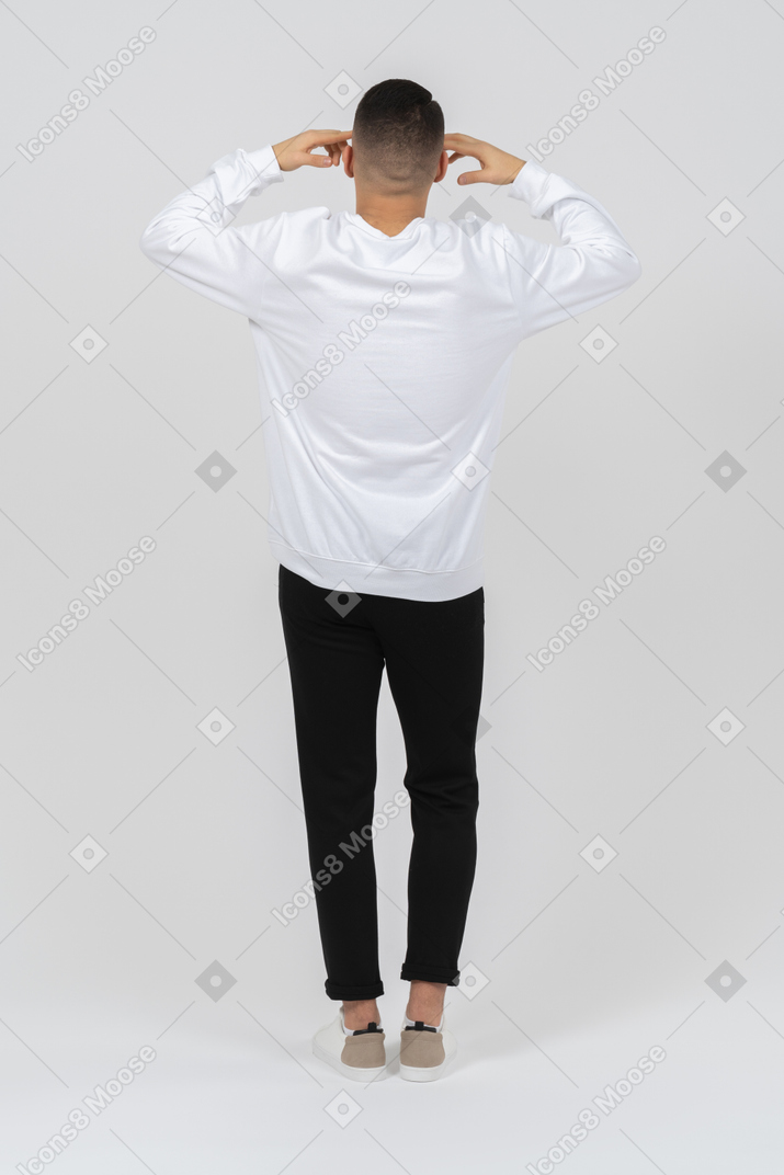 Rückansicht eines mannes in freizeitkleidung mit händen zum kopf