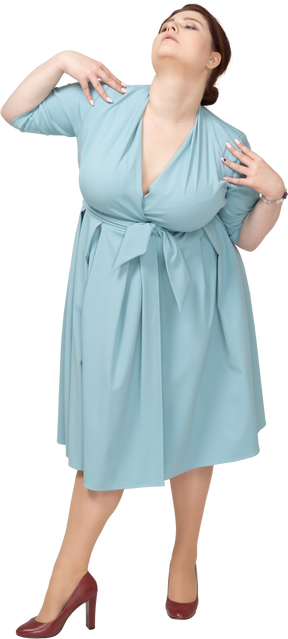 Vista frontal de uma mulher de vestido azul em pé com as mãos nos ombros