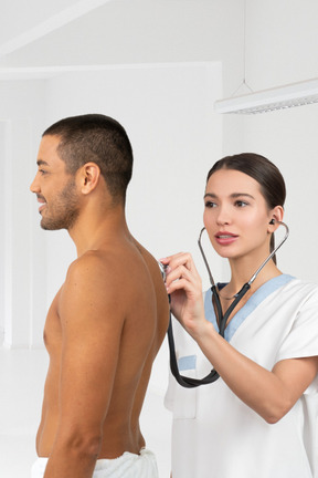 A doctor auscultating a patient