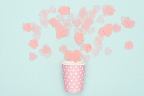 Confetti scattered from polka dot pink paper cup