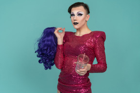 Portrait of a drag queen holding wig & plastic cup
