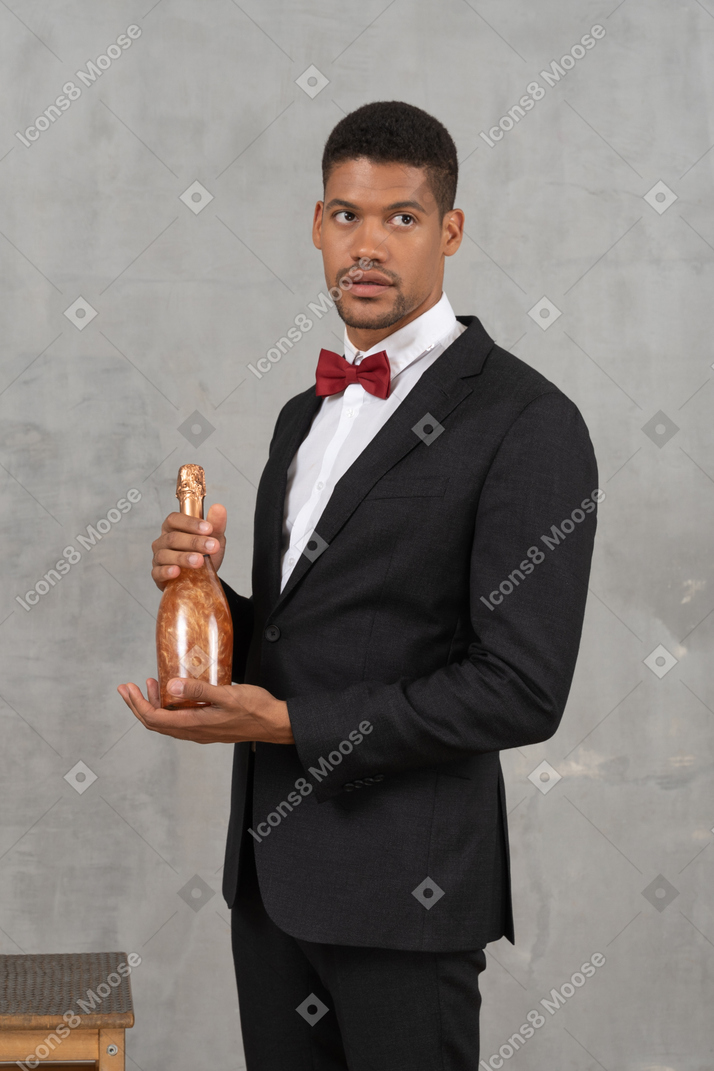 Man in formal wear posing with a champagne bottle