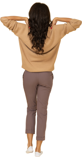 Vista posterior de una mujer joven de piel oscura tocando sus hombros