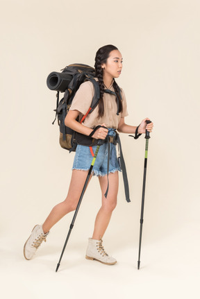 Donna escursionista a piedi con bastoncini da trekking