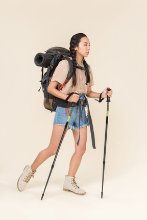 Hiker woman walking using trekking poles