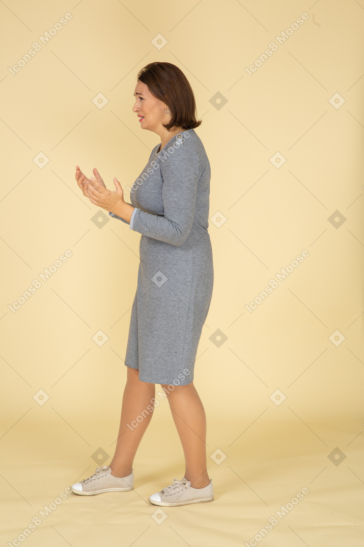 Side view of a woman in grey dress gesturing