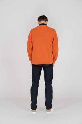 Young man in orange sweatshirt standing