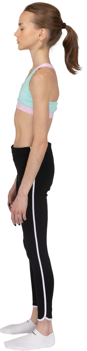 Side view of a teen girl in sportswear standing still with her eyes closed
