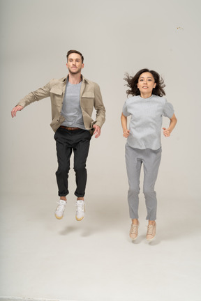 Молодой мужчина и женщина прыгают вместе