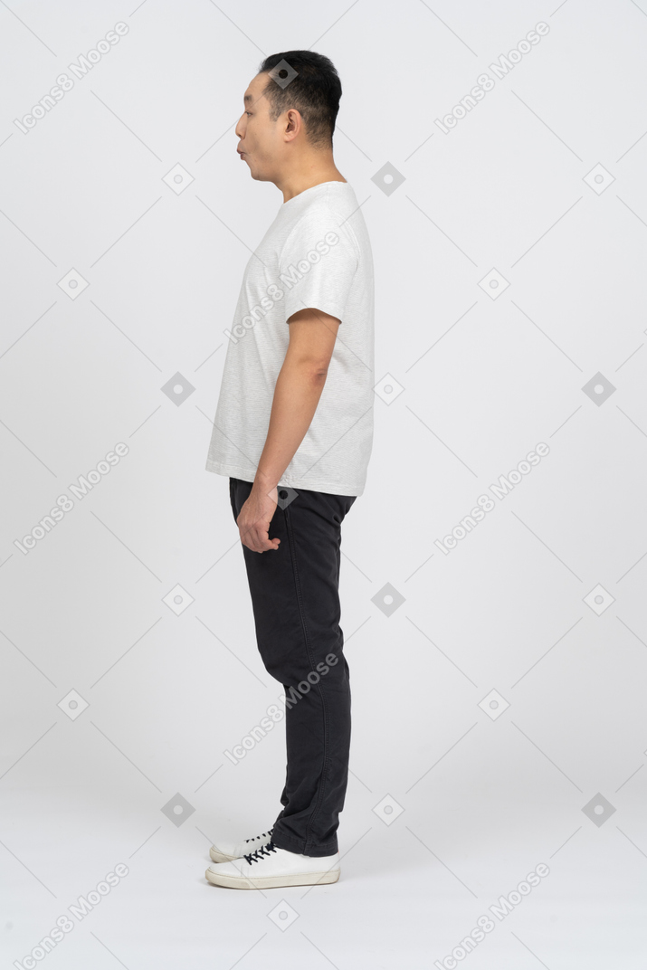 Side view of a man in casual clothes making funny face