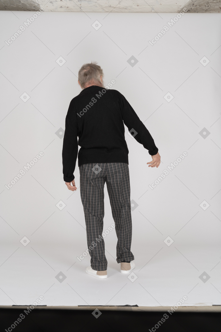 Uomo anziano con le braccia lateralmente rivolte lontano dalla fotocamera
