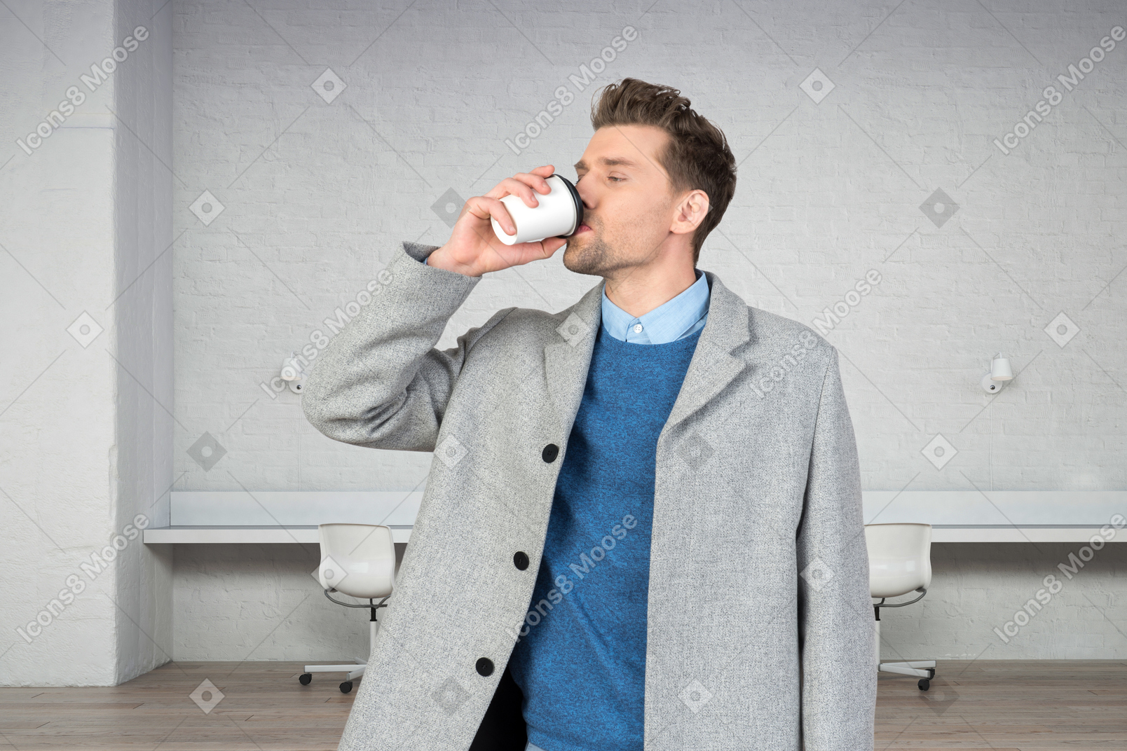 A man drinking a coffee in an office