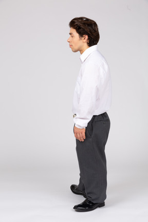 Side view of young man standing and looking aside
