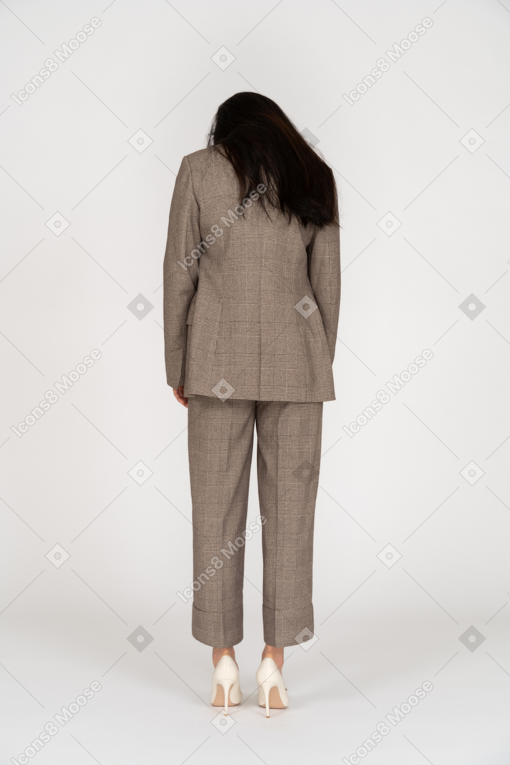 Vista posterior de una señorita en traje marrón mirando hacia abajo