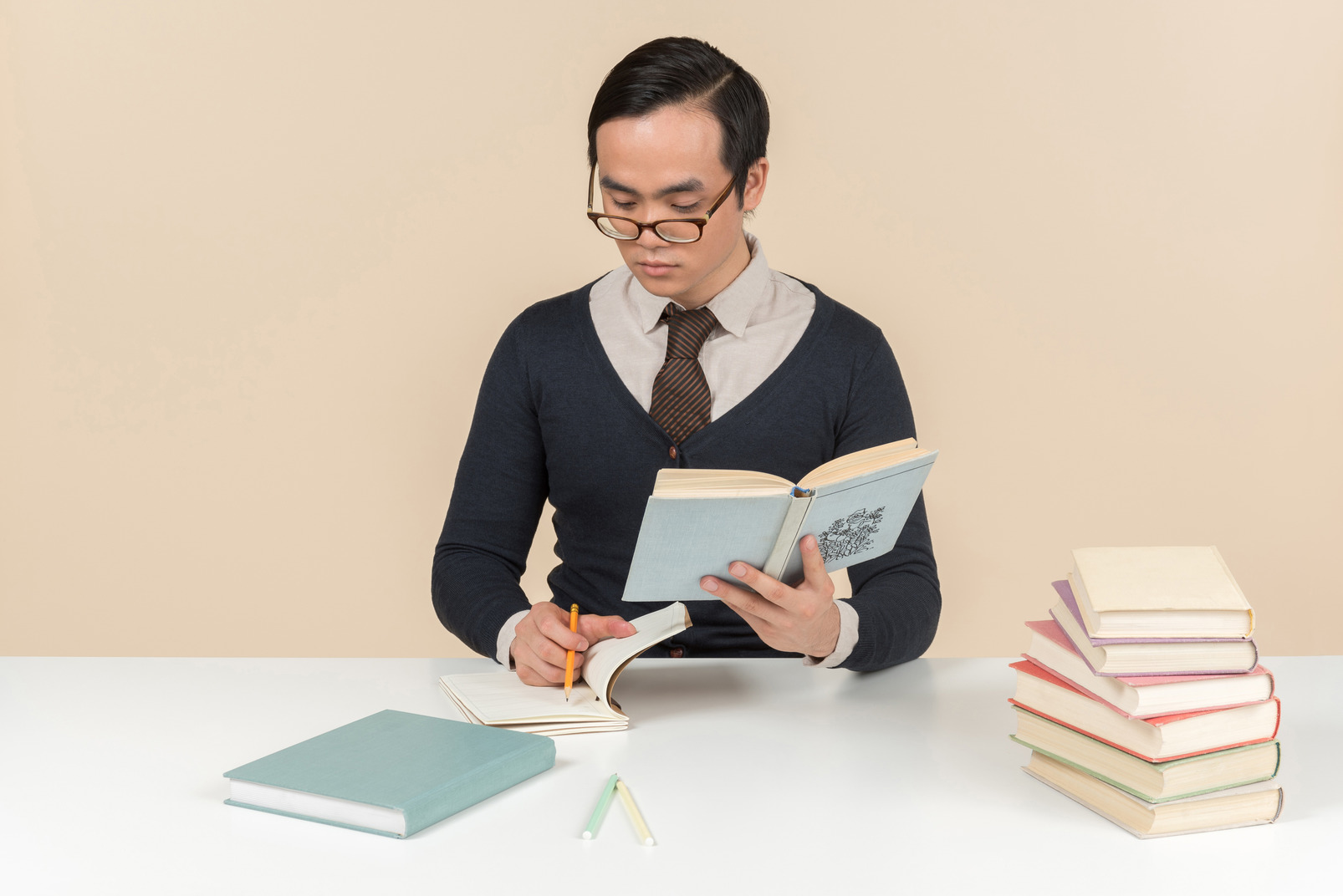 Young asian student in a sweater reading a book