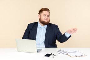 Not worried about anything young overweight office worker sitting at the office desk