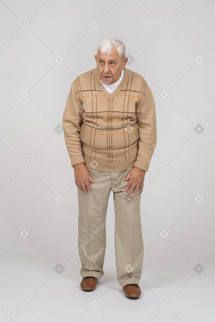 Front view of an old man in casual clothes looking up