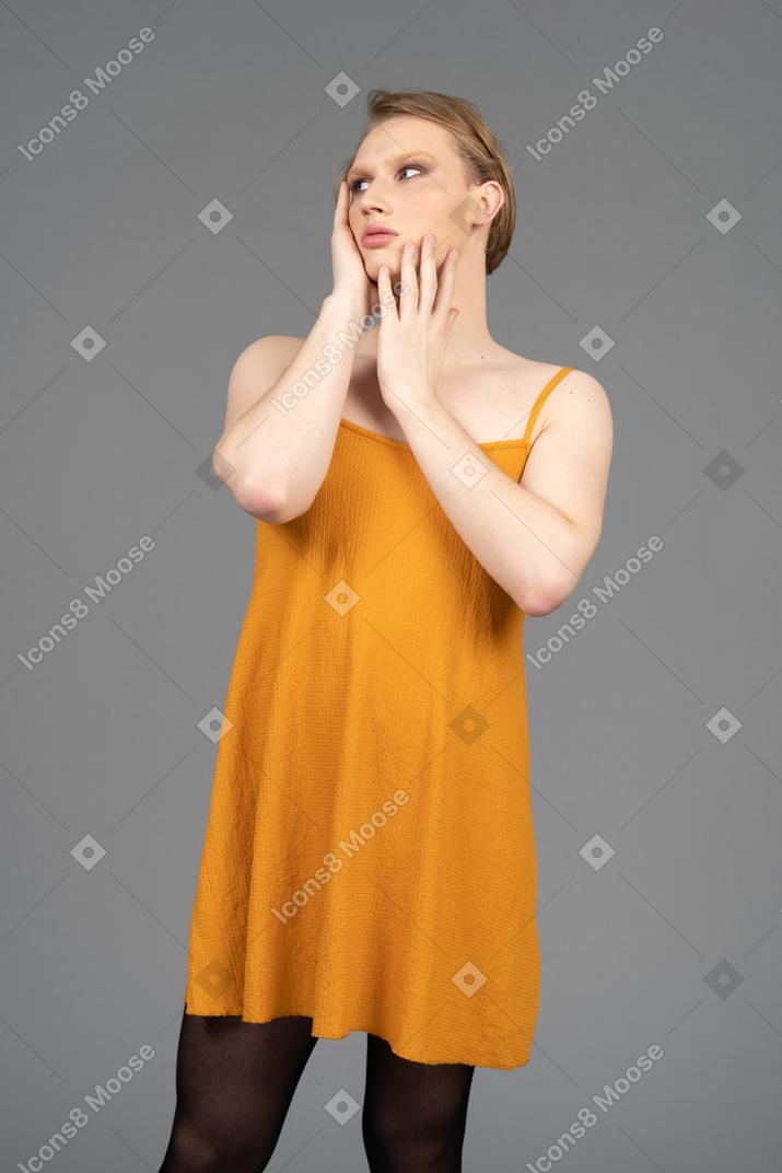 Young transgender person touching their face