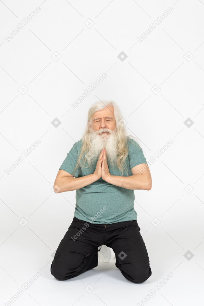 앉아서 기도하는 노인의 전면 모습