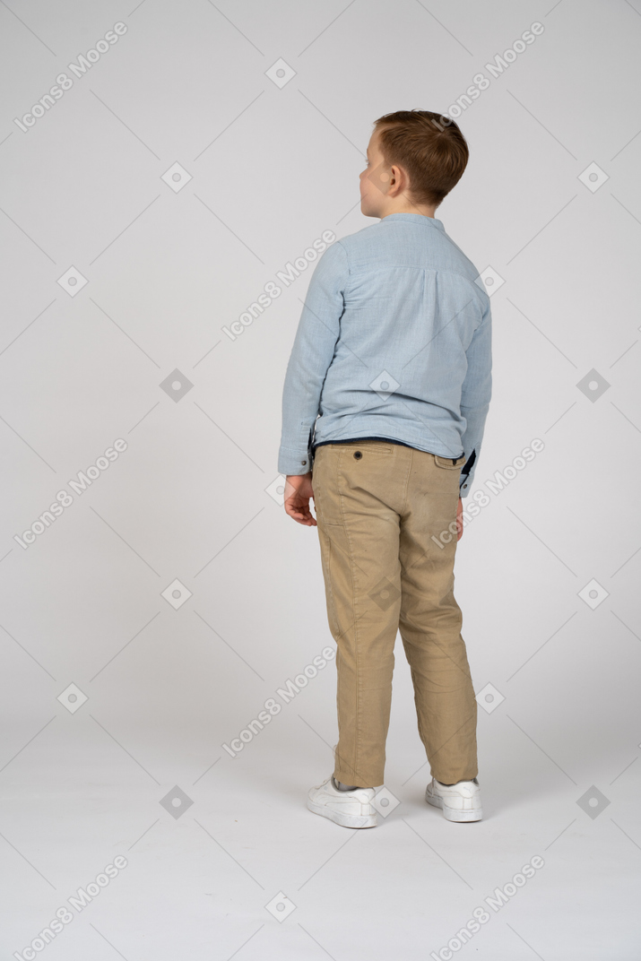 Boy standing back to camera and looking aside