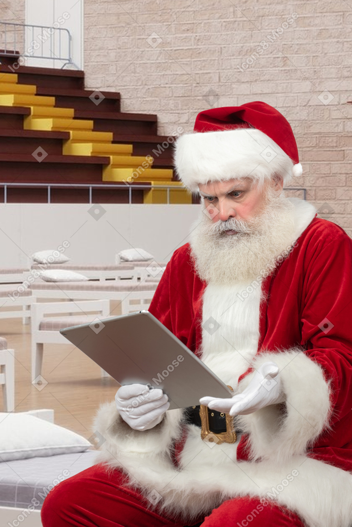 Santa claus reading christmas mail in a temporary hospital