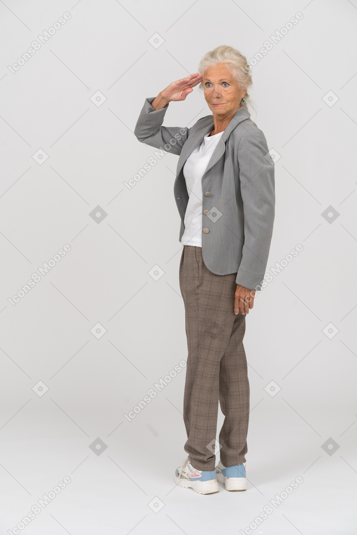 Rear view of an old lady in suit saluting with hand