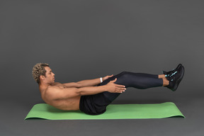 Side view of a shirtless afro man doing crunches