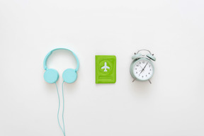 Blue headphones, passport cover and alarm clock