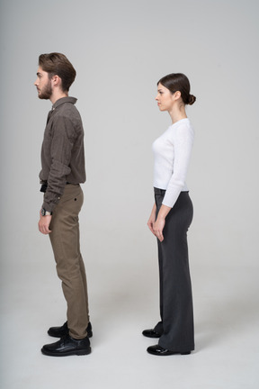 Vista lateral de una joven pareja en ropa de oficina de pie todavía