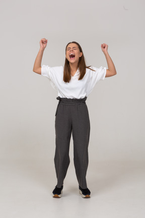 Vista frontale di una giovane donna urlante in abiti da ufficio che alza la mano
