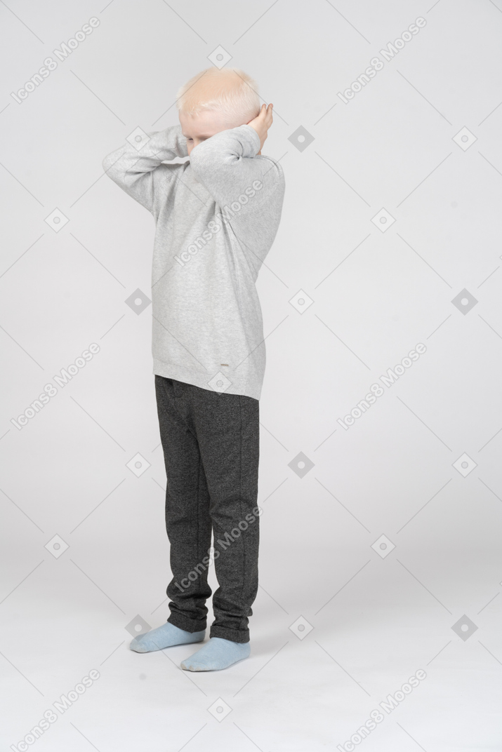 Scared boy covering his ears with hands