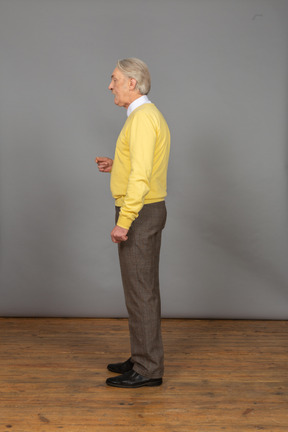 Side view of an old man talking and gesticulating