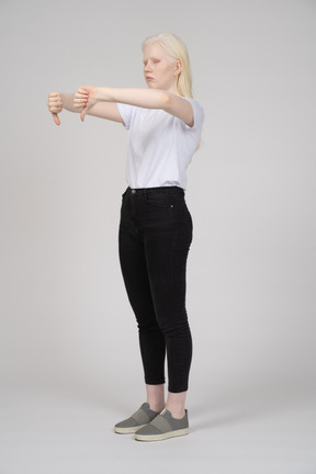 Three-quarter view of a blonde girl with two thumbs down