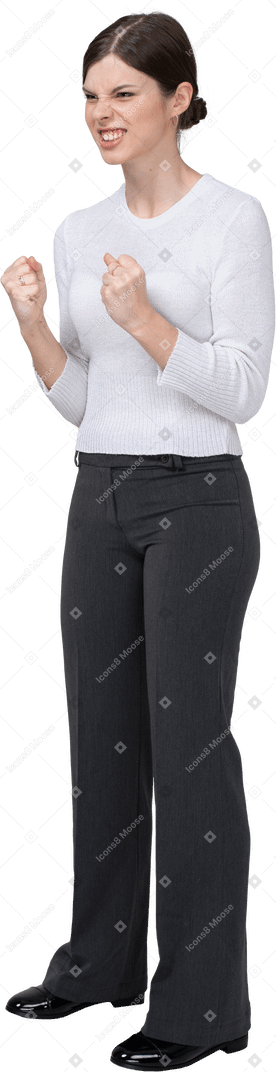 Three-quarter view of a furious woman in office clothing clenching fists