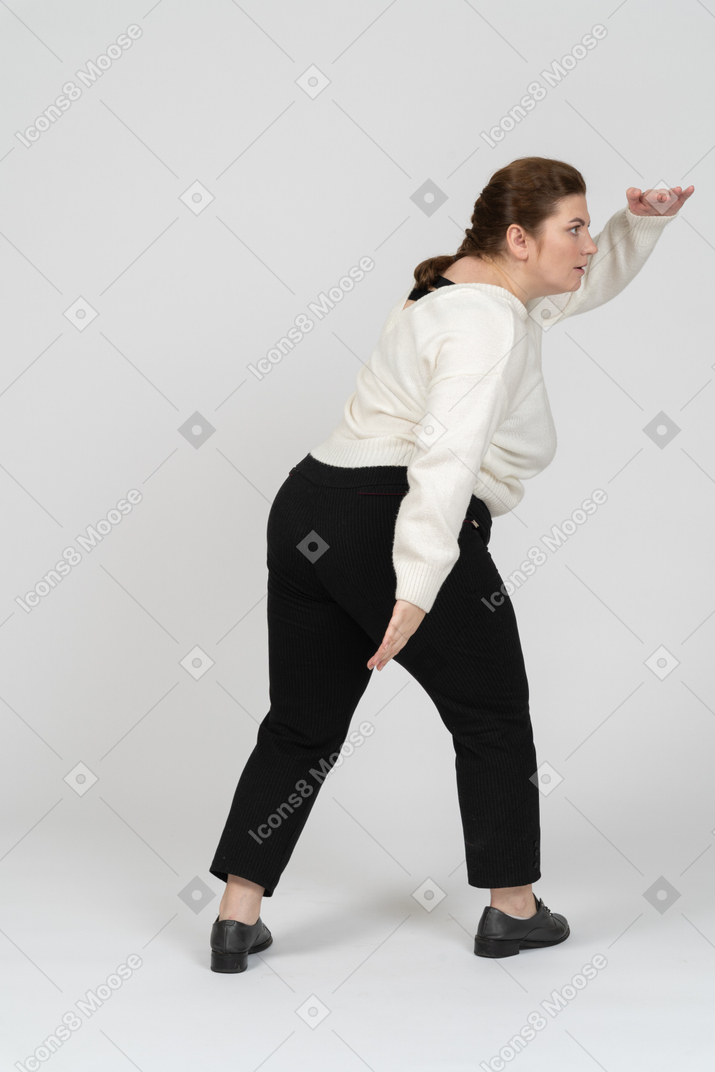 Rear view of plump woman in casual clothes looking for someone
