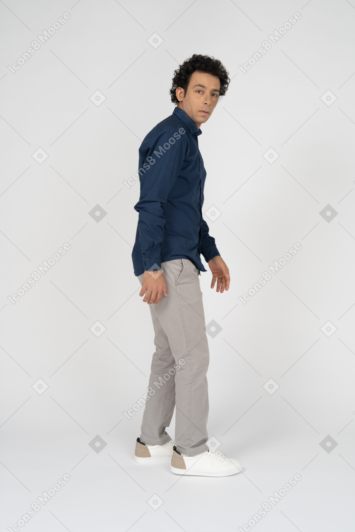 Vista lateral de um homem com roupas casuais olhando para a câmera