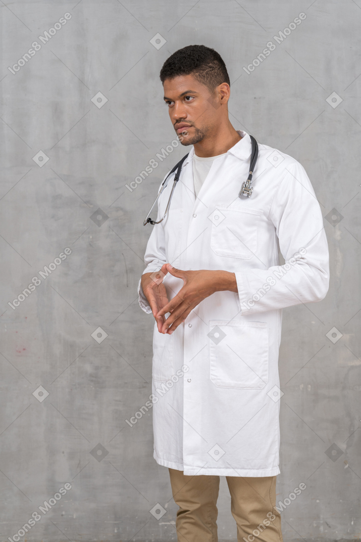 Молодой врач сцепляет пальцы