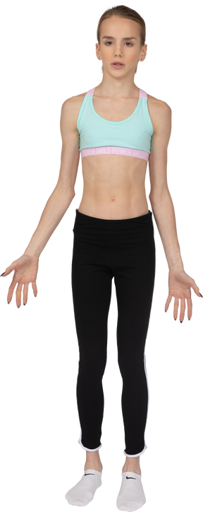 Vista frontal de uma adolescente descontente em roupas esportivas cruzando as mãos