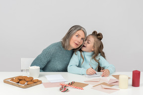 Avó e neta escrevendo uma carta para santa juntos